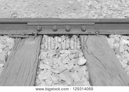 railway track joint with bolt and nut on railroad sleepers in black and white tone