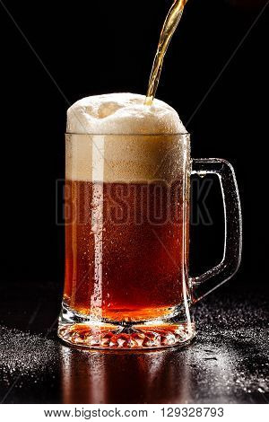 Process Filling Beer Glass With Drops On Black. Fresh! Much Foam! Beer Bubbles Closeup. Draft. Overf