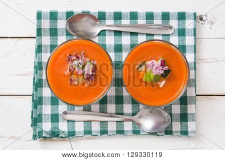 Homemade gazpacho soup in glass on white wooden table