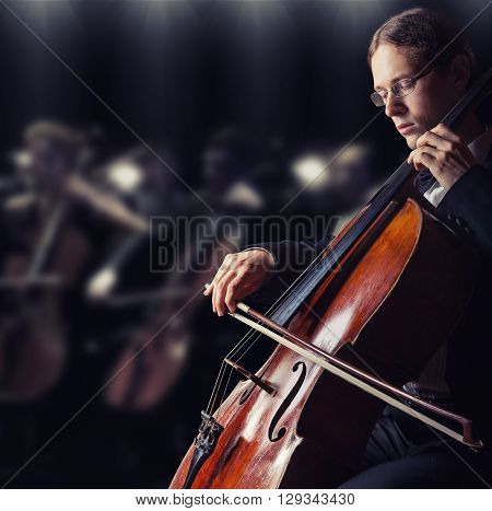 Close-up of cellist playing classical music on cello in the orchestra