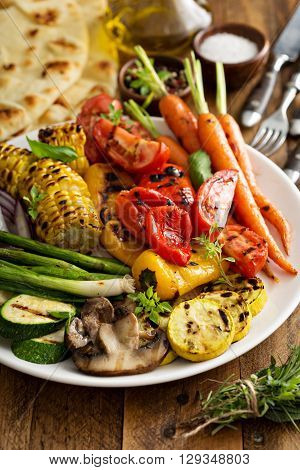 Grilled vegetables and chicken on wooden table overhead shot