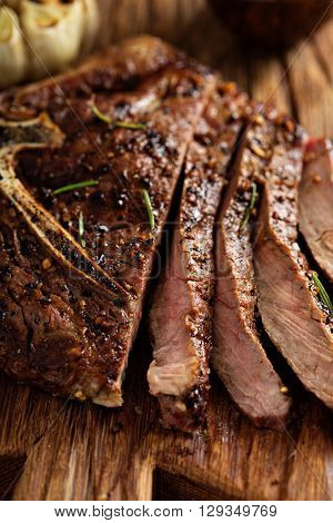 Tbone beef steak cooked on a grill with rosemary and garlic