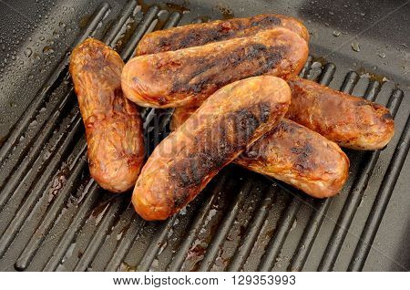 Freshly cooked pork sausages in a non stick griddle frying pan