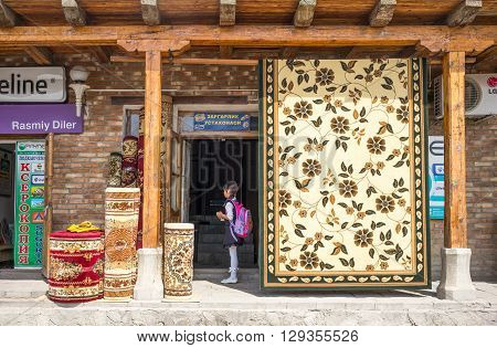 Buckara Uzbekistan - Aprilr 16 2014: A schoolgirl in the market on the side of the Kalon mosque