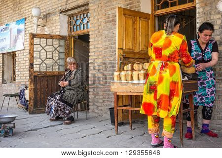Buckara Uzbekistan - Aprilr 16 2014: Local people and vendors in the market on the side of the Kalon mosque