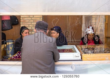Buckara Uzbekistan - Aprilr 16 2014: Local people and vendors in the market on the side of the Kalon mosque