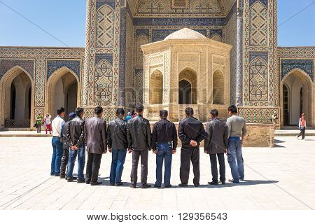 Buckara Uzbekistan - Aprilr 16 2014: Local people in the inside square of the Kalon mosque