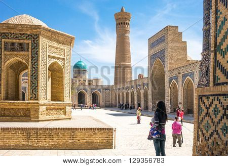 Buckara Uzbekistan - Aprilr 16 2014: Local people and tourists in the inside square of the Kalon mosque