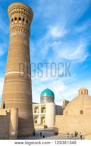 Buckara Uzbekistan - Aprilr 16 2014: Local boys playing under the Kalon minaret with the Mir-i-Arab madrassah in the background