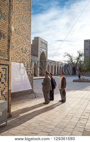Buckara Uzbekistan - Aprilr 16 2014: Local people in the inside square of the Kalon mosque