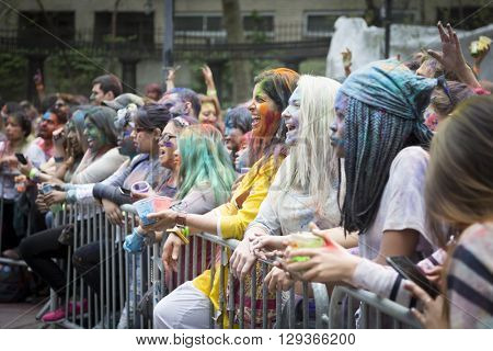 NEW YORK - APR 30 2016: A large crowd with colorful powder on their faces celebrate Holi Hai Festival of Colors and watch performers on the stage hosted by NYC Bhangra in New York on April 30 2016.