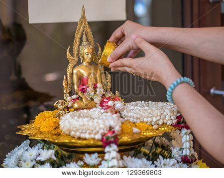 Pour water onto a Buddha statue in Songkarn festival