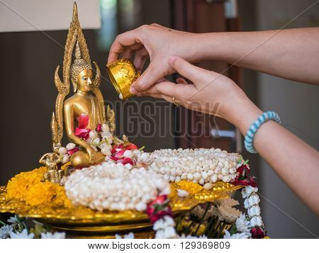 Pour water onto a Buddha statue in Songkarn festival