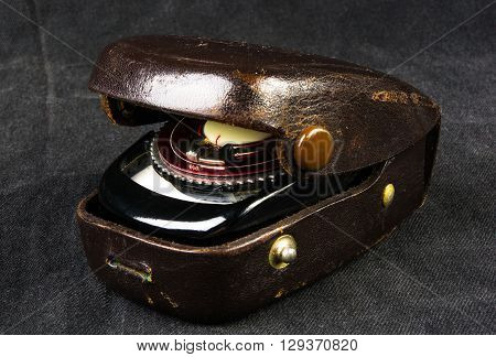 old vintage Soviet exposure meter with leather case on black background