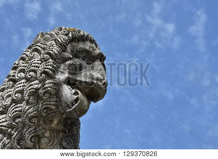 Ferocious lion head. Detail of an ancient lion statue in the Lucca medieval walls gardens