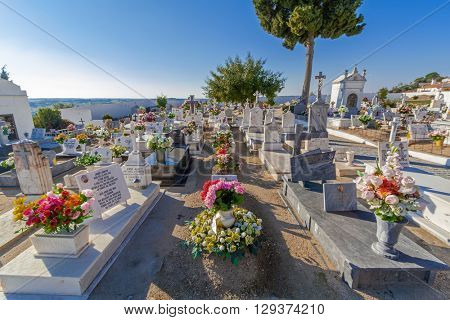 Crato, Portugal. December 12, 2015: Typical Catholic cemetery with the graves decorated with flowers in the interior south of Portugal.