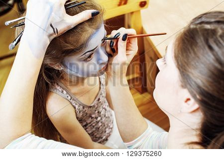 little cute child making facepaint on birthday party, zombie Apocalypse facepainting, halloween preparing concept at home