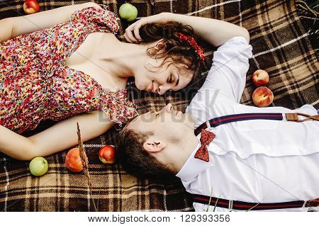 Beautiful Happy Bride And Stylish Retro Groom Lying On Tweed Blanket, Cuddling And  Relaxing, Picnic