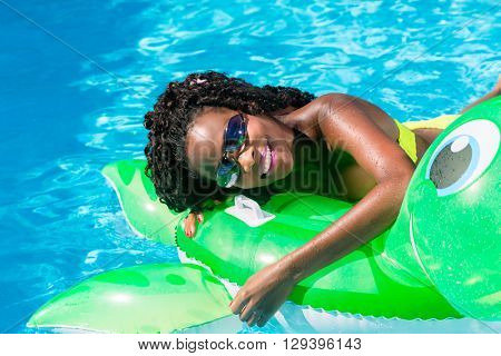 Girls in swimming pool water with inflatable animal