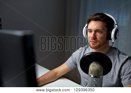 technology, gaming, entertainment, let's play and people concept - young man in headset with pc computer playing game at home and streaming playthrough or walkthrough video