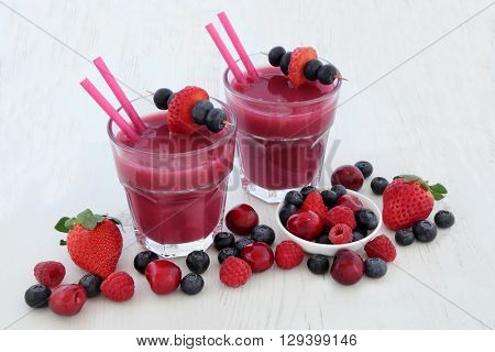 Superfood smoothie health drinks with raspberry, strawberry, cherry and blueberry fruit. High in vitamins, anthocyanins and antioxidants.