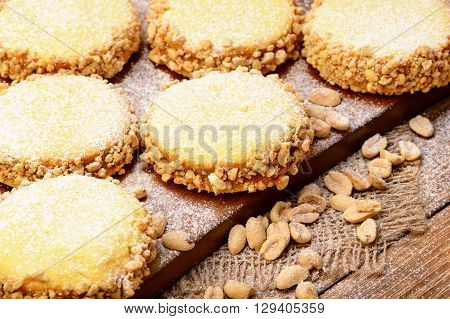 Butter cookies (alfajores) with caramel and peanut on wooden background.