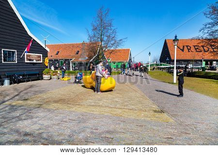Zaanse schans, Netherlands - April 1, 2016:  People taking photos near big wooden shoe, clog or klomp, Zaanse Schans village, Holland