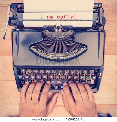 The sentence I am sorry against white background against businessman typing on typewriter