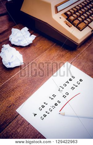 The sentence a cat in gloves catches no mice against white background against view of an old typewriter and paper