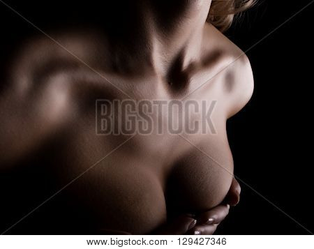 body of beautiful sexy female neck, collarbone and chest. naked body on a black background.