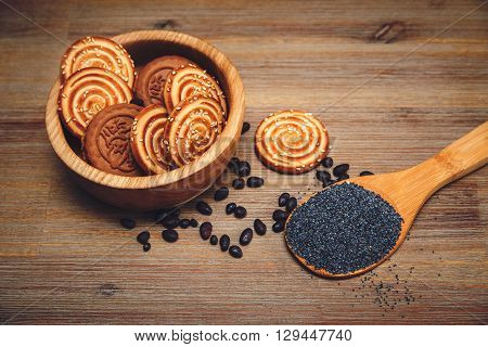 There are Pieces of Roll with Poppyseed and Cookies,Halavah and Chocolate Peas.Tasty Sweet Food on the Wooden Background,Toned