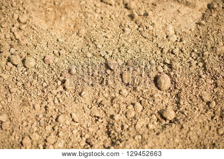 Brown lumpy soil in a shady light as a background