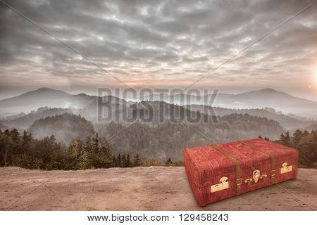 Wooden suitcase against beautiful scene of trees and mountain