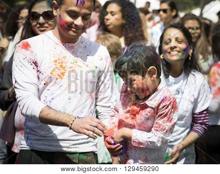 NEW YORK - APR 30 2016: A family celebrates Holi Hai Festival of Colors with colorful powder on their faces in Dag Hammerskjold Plaza hosted by NYC Bhangra in New York on April 30, 2016.