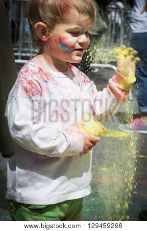 NEW YORK - APR 30 2016: An unidentified boy celebrates Holi Hai Festival of Colors with colorful powder on his face in Dag Hammerskjold Plaza hosted by NYC Bhangra in New York on April 30, 2016.
