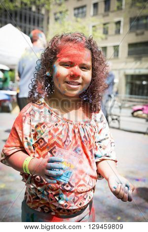 NEW YORK - APR 30 2016: An unidentified girl celebrates Holi Hai Festival of Colors with colorful powder on her face in Dag Hammerskjold Plaza hosted by NYC Bhangra in New York on April 30, 2016.