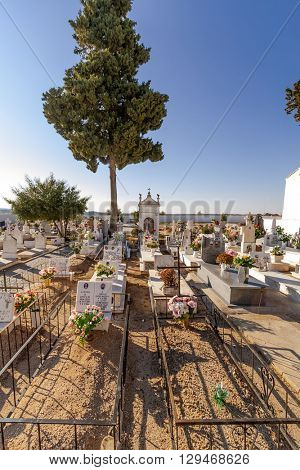 Crato, Portugal. December 12, 2015: Poor people graves in a typical Catholic cemetery with the graves decorated with flowers in the interior south of Portugal.