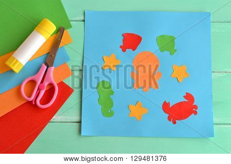 Paper applique with sea animals and fishes. Art lesson in kindergarten. Paper sea animals - octopus, fish, starfish, seahorse, crab. Kids crafts. Sheets of colored paper, scissors, glue