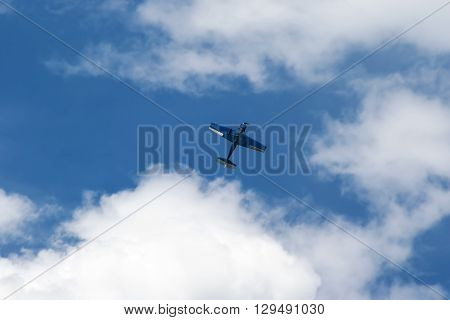 In the blue sky with clouds flying blue plane