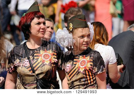 Orel Russia - May 9 2016: Celebration of 71th anniversary of the Victory Day (WWII). Woman and girl with field caps and st.George ribbons closeup