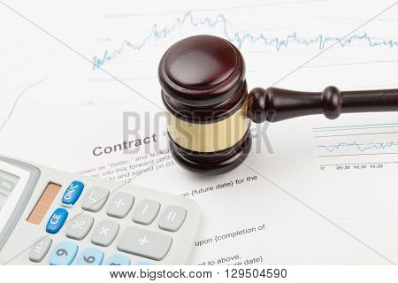 Wooden Judge's Gavel And Calculator Over Some Financial Documents