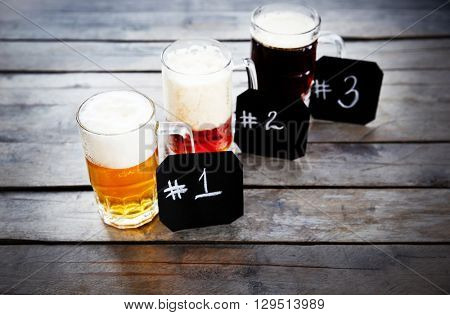 Glasses with different sorts of craft beer and numbering on wooden table. Retro stylization