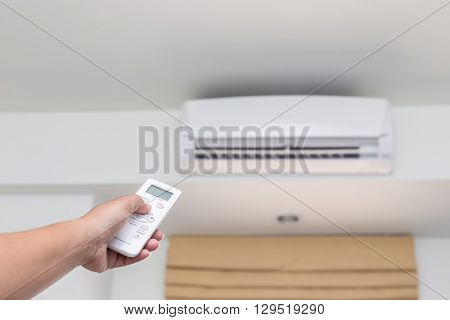 Hand Holding Remote Control Directed On The Conditioner