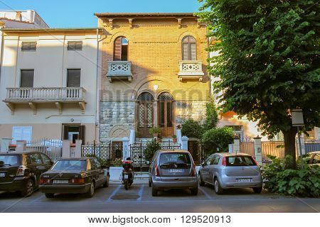 Viareggio Italy - June 28 2015: Parked cars and motorbike on the street in city centre. Viareggio is the famous resort on the coast of the Ligurian Sea