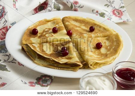 many thin pancakes with jam on the table