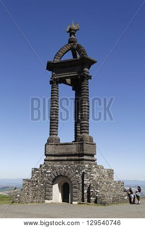 GERGOVIE FRANCE May 5 2016 : Tourists loook at the monument on the Gergovie Plateau dedicated to Vercingetorix designed by Jean Teillard in 1903.