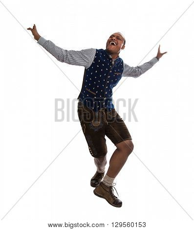 Dancing dark-skinned man wearing traditional clothes for the munich beer festival called Oktoberfest. Person isolated over 