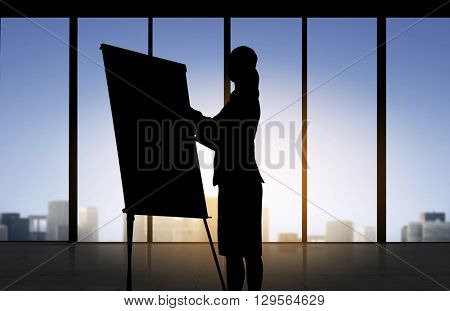 business, strategy, planning and people concept - silhouette of woman with flipboard over office window background