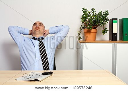 Manager leans back relaxed. he is pleased