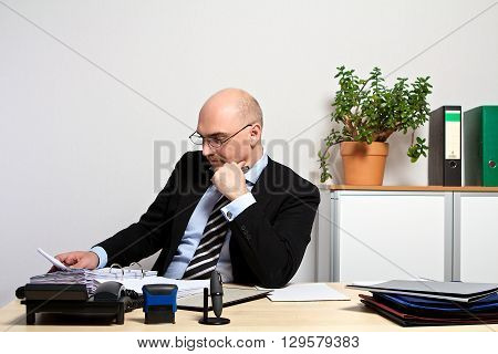 Manager studies his documents. He is focused